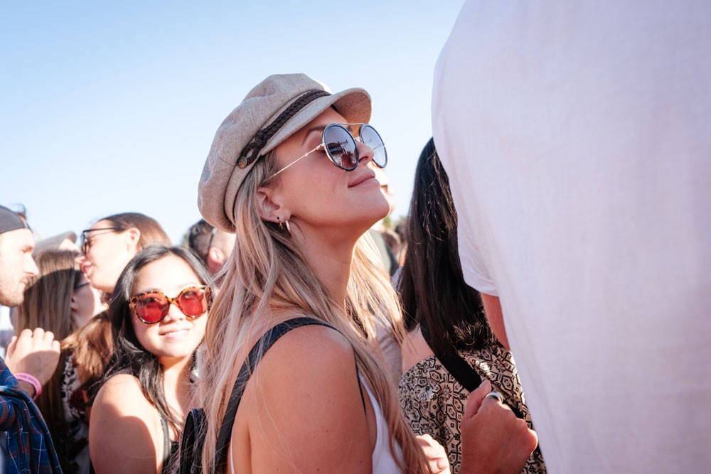 chica rubia sonriendo y rodeada de gente